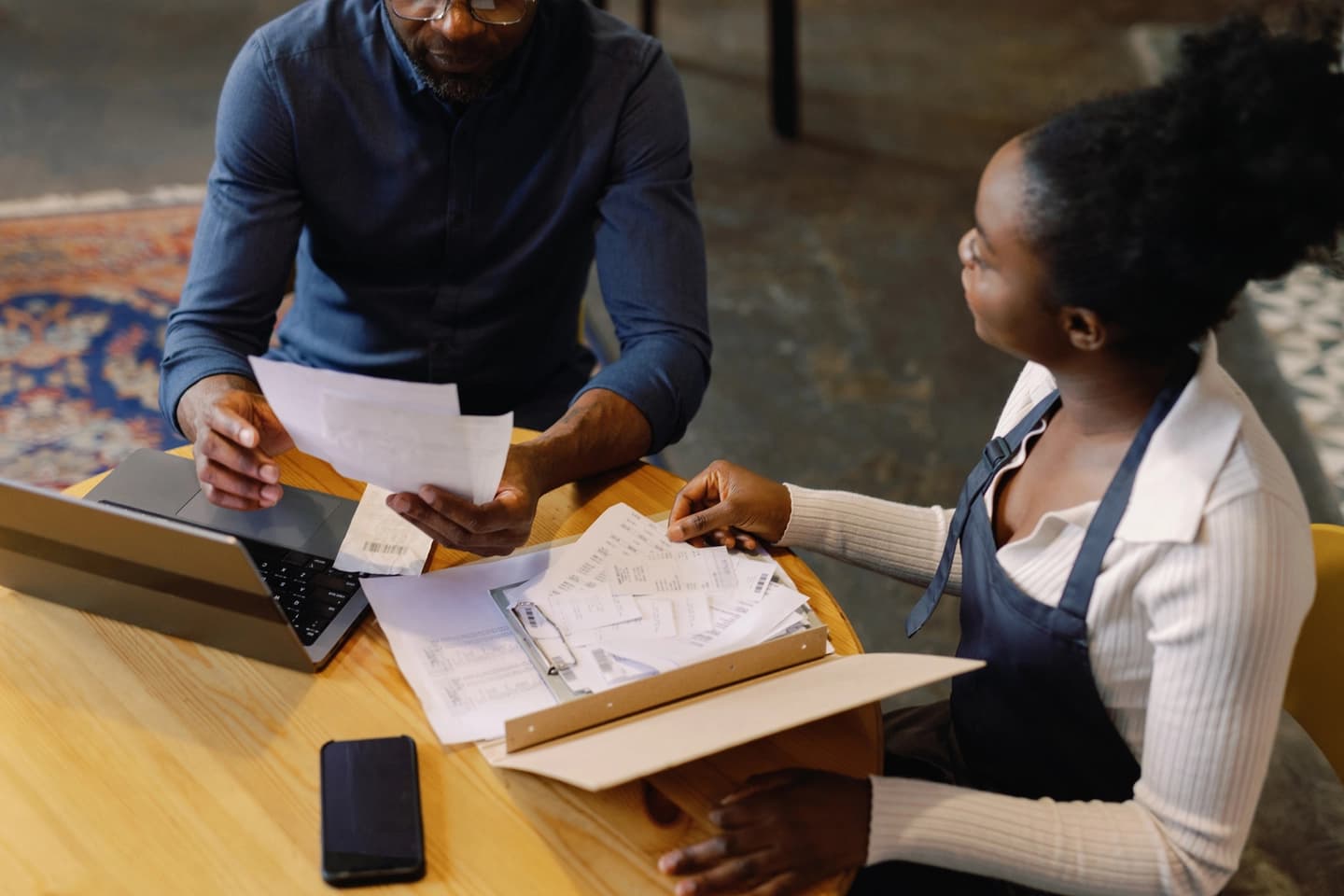 Two people reviewing payment paperwork together at a table